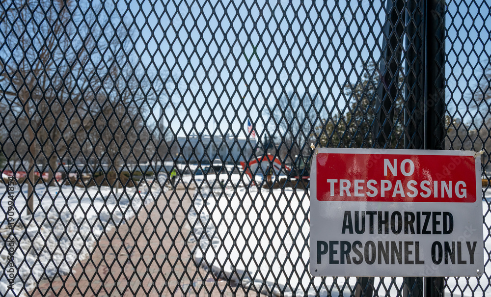 Naklejka premium No trespassing sign displayed on a fence with snow coverage in the background at the United States White House in Washington DC