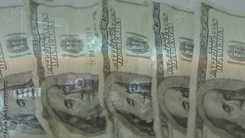 Hand entering from right fanning US 100-dollar bills and flattening them under glass for scanning