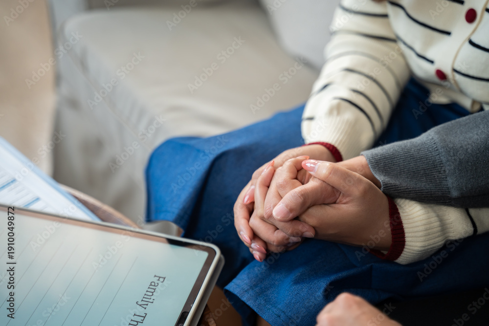 Fototapeta premium Young Asian couple or family sitting on sofa and talking with a professional therapist at home or clinic.Family therapy,Marriage,counselling,support relationship,trauma advice or mental health concept
