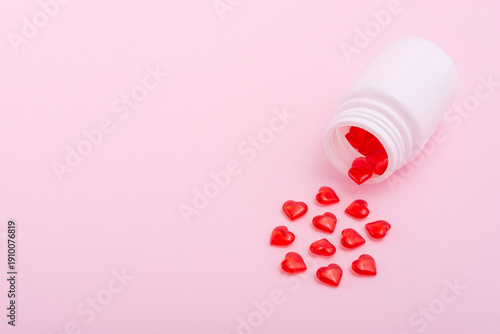Billede på lærred Red heart-shaped pills and plastic bottle