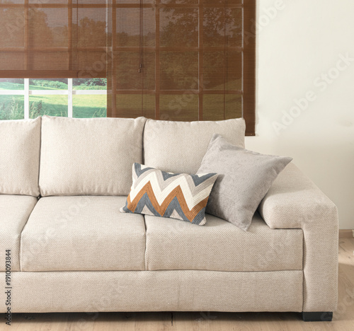 Obraz na plátne A cozy living room featuring a modern beige sofa placed in front of a window wit