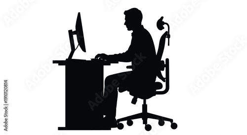 Silhouette of a focused professional working diligently on a computer at an ergonomic desk setup