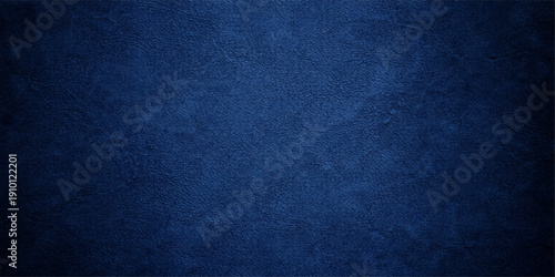 A dark blue grunge denim fabric texture with a rough vintage canvas pattern creates a deep textile backdrop for fashion design and wallpaper