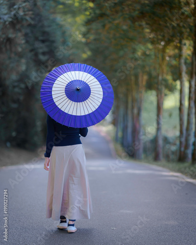 Happy Asian Woman Walking with Japanese Wagasa Umbrella in Nature