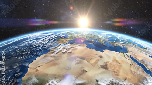 The bright sun rises over the curved horizon of planet Earth from outer space.