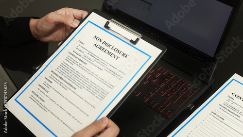 Fotografía Serious business person hands holding non disclosure agreement paper clipboard n
