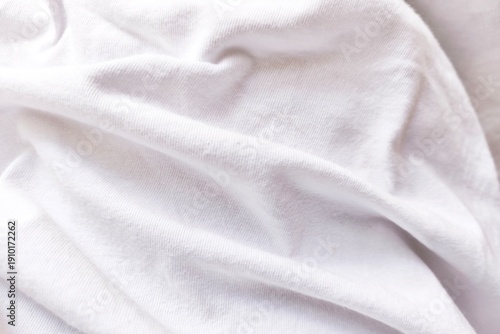White fabric texture background with soft folds and smooth textile surface. Close-up of clean cloth material suitable for fashion design, medical background, product presentation, and minimal style co