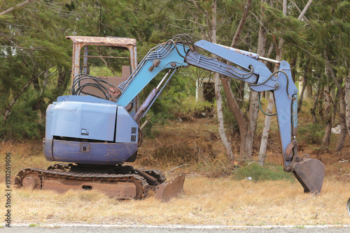 Abandoned, rusty, old crawler excavator left to rot in the forest, industrial decline and heavy equipment concept.