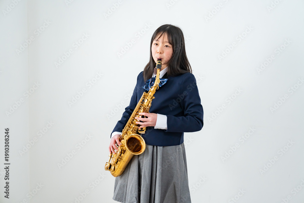 Fototapeta premium アルトサックスを持って笑顔の制服姿の日本人少女