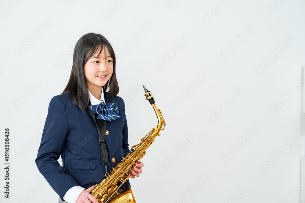 Fototapeta premium アルトサックスを持って笑顔の制服姿の日本人少女