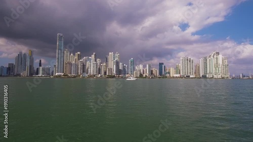 Wallpaper Mural Low flying drone moves toward a boat in Panama City Bay with dramatic clouds over the skyline. Torontodigital.ca