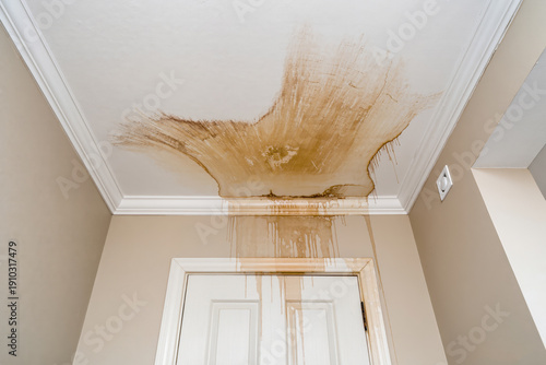 Water stains mark the ceiling of a tired hallway