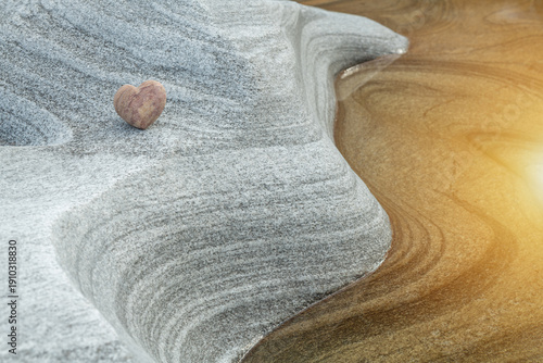 Heart on Layered Gneiss Stone Surface with Warm Light