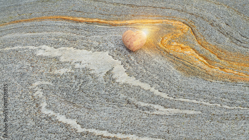 Heart‑Shaped Stone on Textured Rock Surface with Warm Glow