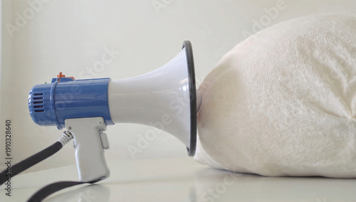 Megaphone muffled by white cloth on white background
