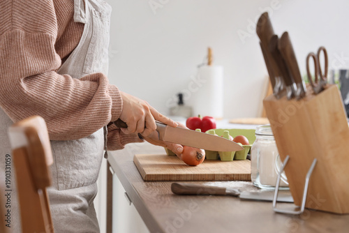 Woman cutting onion with kn...