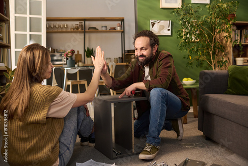 Fényképezés Caucasian young adult man and Caucasian young adult woman assembling furniture t