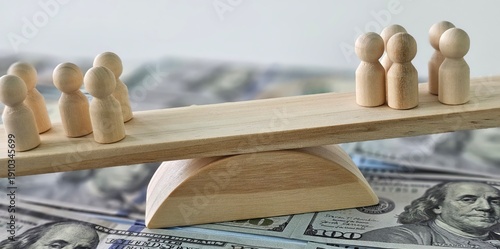 Photos Wooden figures on top of a pile of money symbolize economic inequality and probl