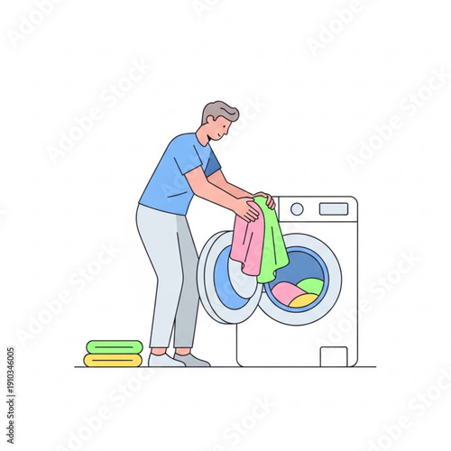 Young man loading colorful clothes into washing machine at home  