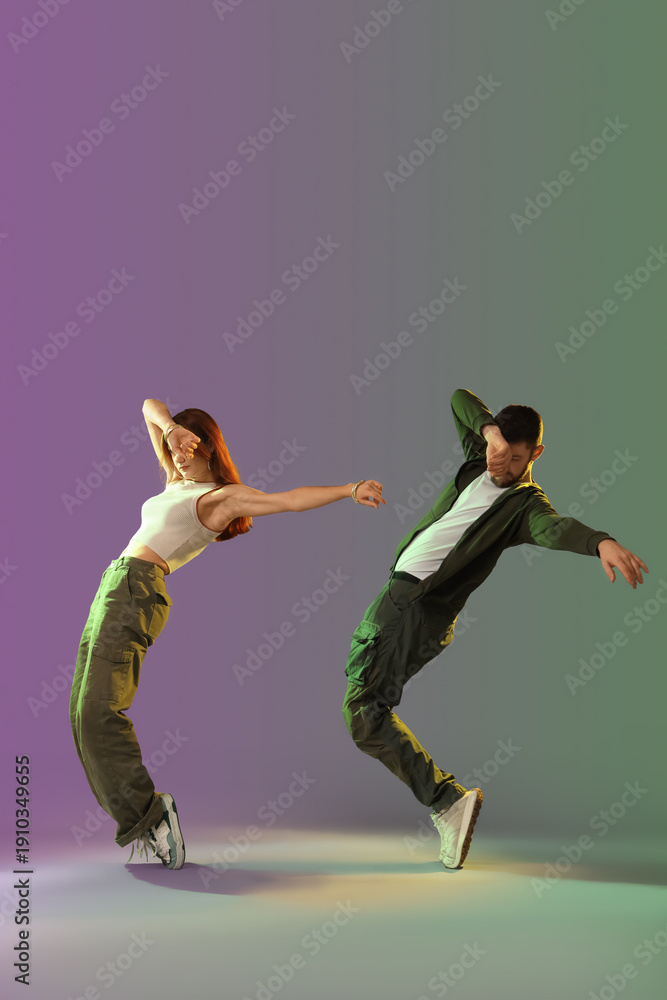 Naklejka premium Young couple of hip-hop dancers on dark background