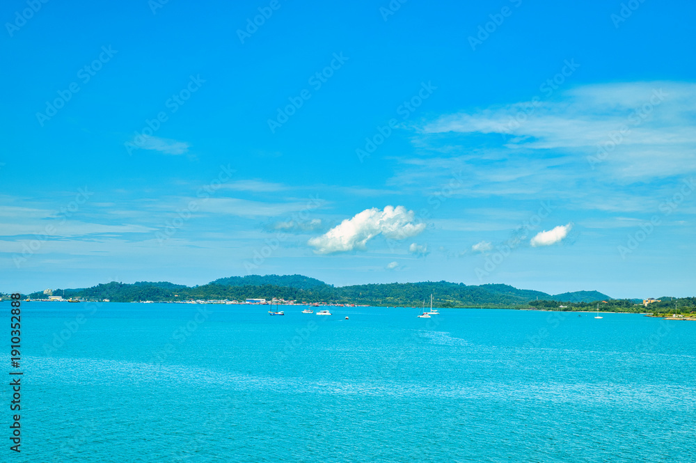Fototapeta premium A beautiful view of Langkawi island against a beautiful blue sky with some boats in the distance on the horizon. Tropical scenery. located at Kedah, Malaysia - September 25 2024: