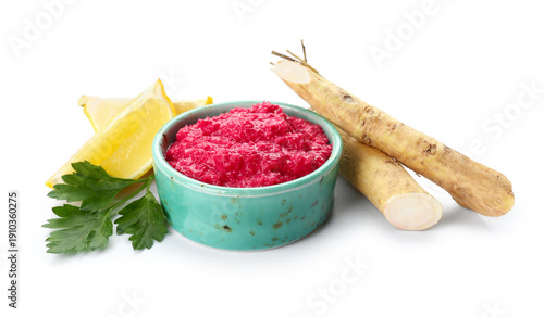 Quadro su tela Bowl of horseradish sauce with beet, lemon and parsley on white background