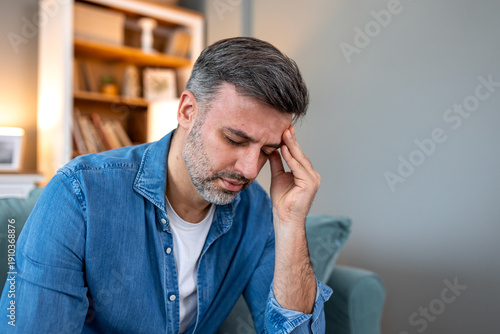 Wallpaper Mural Pain in the head. Severe migraine, Man with headache problem, Healthcare and medicine concept. Middle aged male sitting on the sofa and holding painful temple with hand and eyes closed in distress. Torontodigital.ca