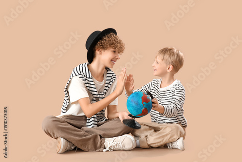 Cute brothers with globe gi...