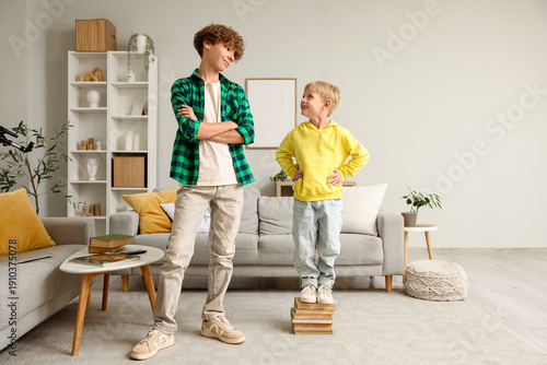 Foto Cute brothers comparing their heights at home
