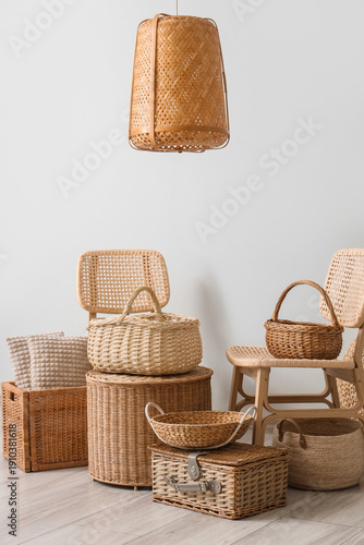 Tableau sur toile Interior of stylish living room with rattan chairs, lamp and different wicker ba