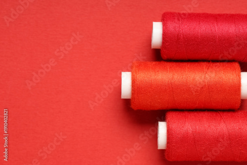 Spools of thread on red bac...