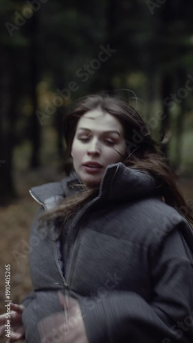 Frightened woman running through autumn forest