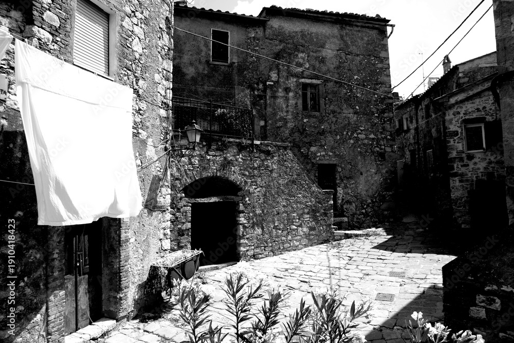 Obraz premium Borghi toscani in bianco e nero. L'architettura medievale dei borghi toscani, caratterizzata da pietra, cotto, riflette il periodo comunale con cinte murarie, torri, vicoli stretti e piazze. Italia. 