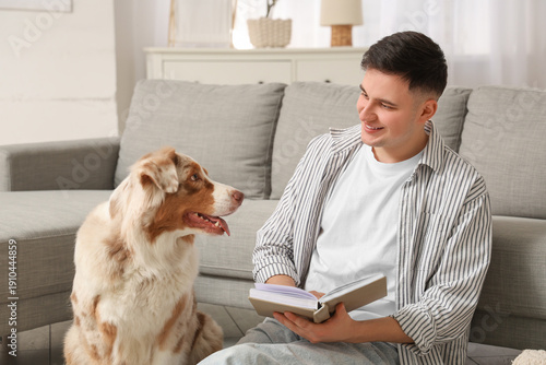 Young man reading book with...