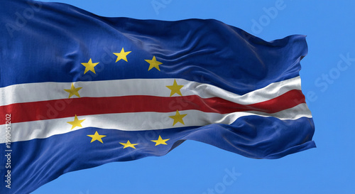 The Cape Verde flag waves majestically in the wind against a clear blue sky, symbolizing national pride and patriotism. Its vibrant colors and dynamic movement evoke a sense of freedom and cultural