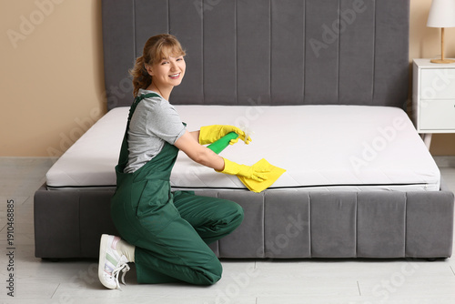 Female janitor cleaning mat...
