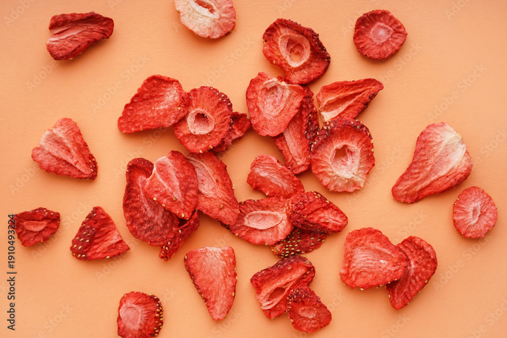 Naklejka premium Tasty freeze-dried strawberries on orange background