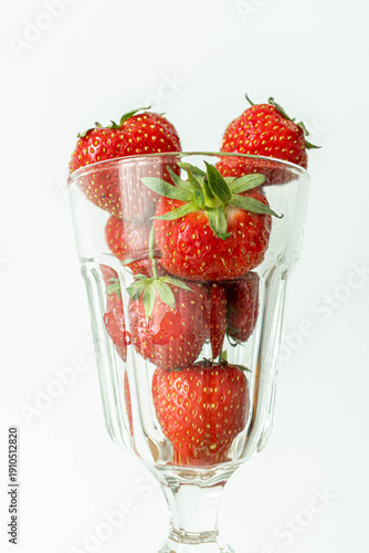 Fresh strawberries in a glass isolated on a light background