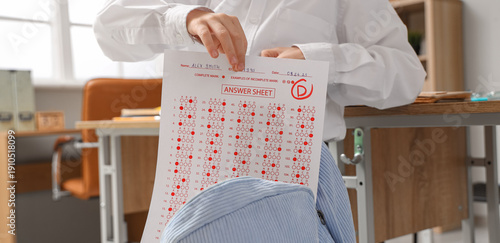 Schoolboy putting answer sh...