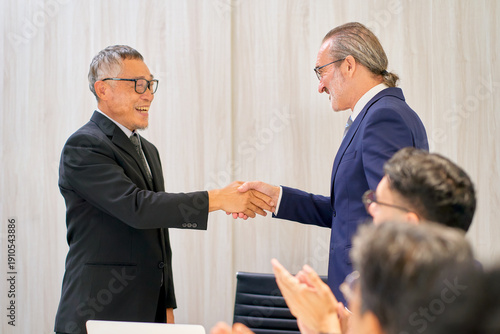 Two businessman manager shake hand together for make a deal or agreement in meeting room.