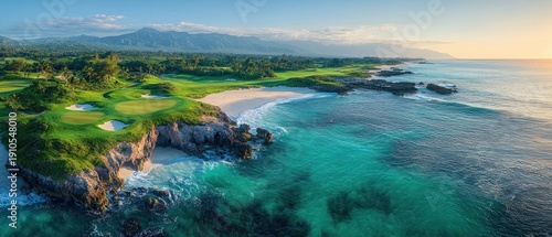 Sunlit coastal golf course on rocky cliffs with emerald fairways, sand bunkers, white sandy cove, turquoise ocean and distant mountains conveying peaceful serenity