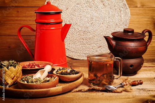 cup of herbal tea and ingredients on wooden table