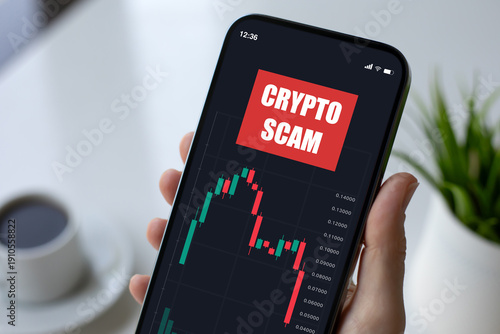 woman hand hold phone with chart of scam crypto coins