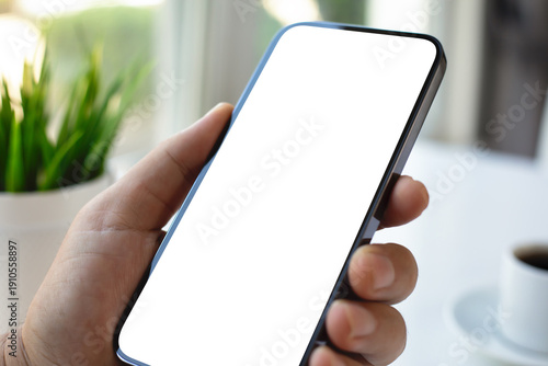 Male hand holding phone with isolated screen over table cafe