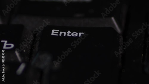 An extreme macro close-up of a computer keyboard focusing on the black “Enter” key with white lettering. A fingertip appears blurred in the foreground as it moves toward or presses the key.