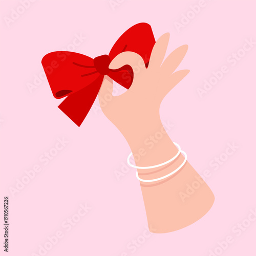 Feminine Hand Holding a Festive Red Bow for Mother's Day