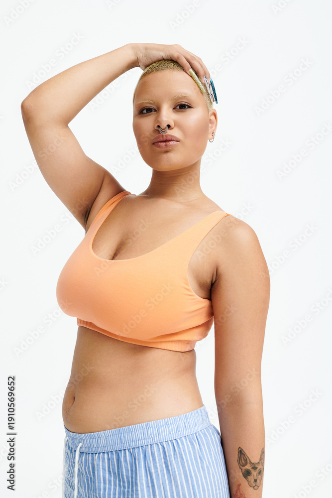 Obraz premium Bold fashion choice by a young woman in a stylish sport bra in a vibrant studio space