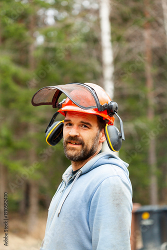 Portrait of man wearing helmet and ear muffs in forest