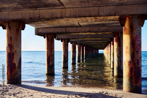 Wallpaper Mural Underneath Baltic Sea pier with rusted columns and calm water Torontodigital.ca