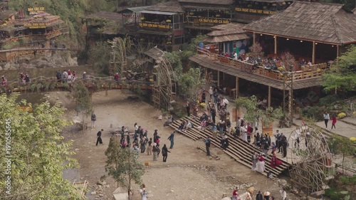 Atmospheric view of Cat Cat Village in Sapa, Vietnam, featuring traditional houses, greenery, riverside and a waterfalls setting that reflects the peaceful mountain village environment.